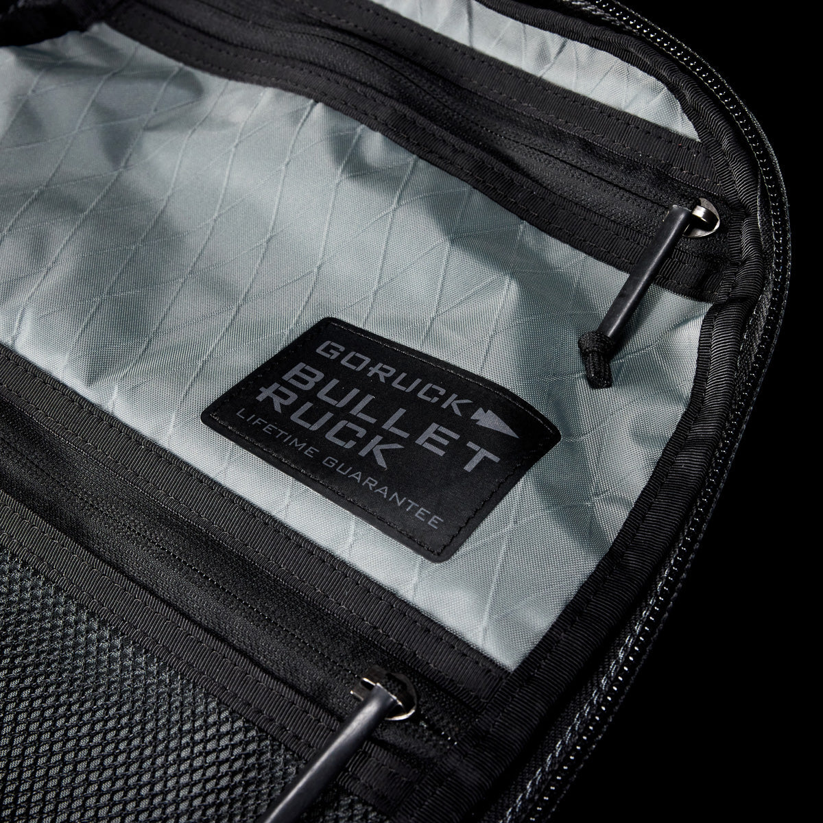 Close-up of the Bullet X-PAC daypack interior with a visible "Lifetime Guarantee" patch. This weatherproof bag is built to last.