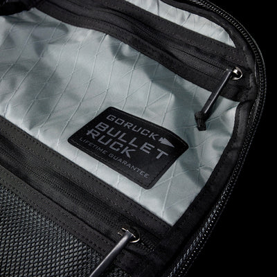 Close-up of the Bullet X-PAC daypack interior with a visible "Lifetime Guarantee" patch. This weatherproof bag is built to last.