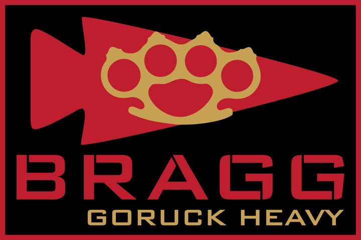 Red arrowhead with a gold brass knuckle above "BRAGG LIVE EVENT 2026" on black, inspired by Fort Bragg and GORUCK Heavy’s Special Forces training roots.