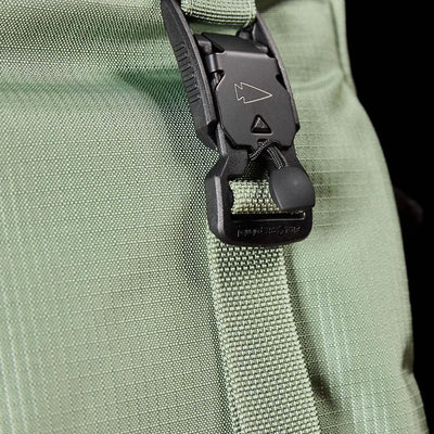 Close-up of the M23 - Ripstop ROBIC® strap in Seaspray, featuring a black plastic buckle characteristic of GORUCK's rugged field packs. The textured grid pattern reflects its durable material, and the small arrow symbol on the buckle adds a touch of precision. The muted colors accentuate the buckle's design.