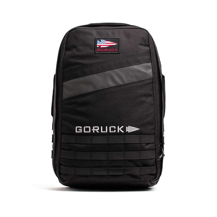Black GORUCK Rucker 4.0 with logo, front zippered pocket, and horizontal reflective strip—ideal for rucking or carrying Ruck Plates—shown on a white background.