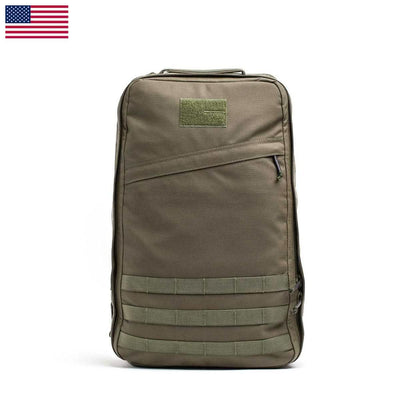 A khaki GR1 USA - Cordura rucksack by GORUCK, featuring MOLLE webbing on the front and a patch area near the top. It stands upright against a white background, with a small American flag in the top left corner, reminiscent of gear used by Special Forces operators.