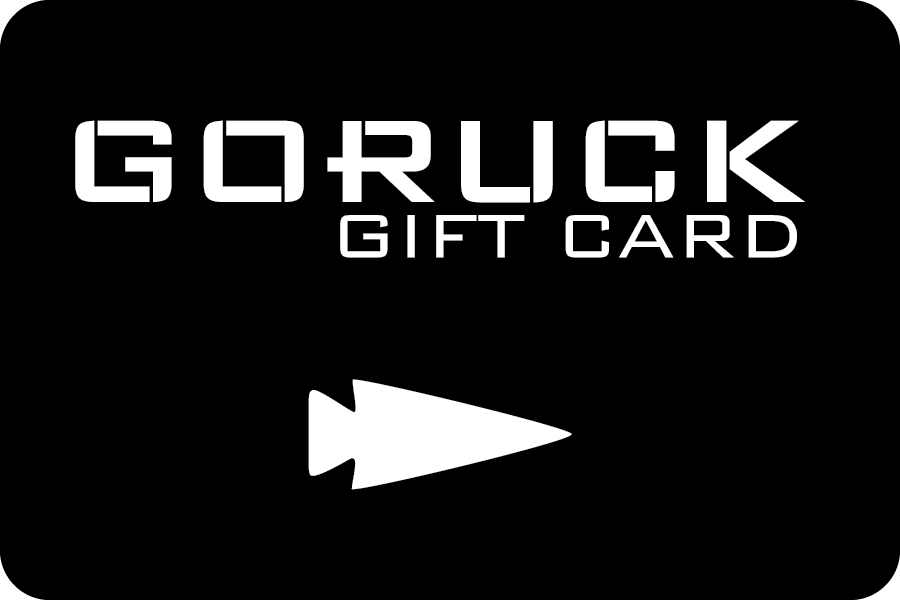 A sleek black GORUCK e-Gift Card with white text displaying "GORUCK Gift Card" and a distinctive white arrowhead symbol at the bottom, ideal for your next gear purchase.