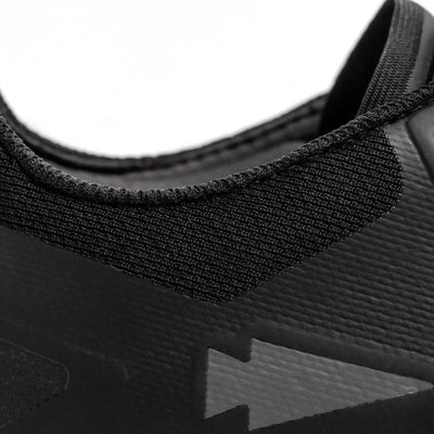 Close-up of the GORUCK Mackall - Black + Forged Iron athletic shoe, perfect for rucking or Special Forces training, emphasizing the textured fabric around the collar and a subtle arrow design on the side. The image showcases the material and stitching details.
