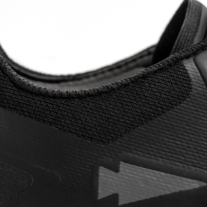 Close-up of the GORUCK Mackall - Black + Forged Iron athletic shoe, perfect for rucking or Special Forces training, emphasizing the textured fabric around the collar and a subtle arrow design on the side. The image showcases the material and stitching details.