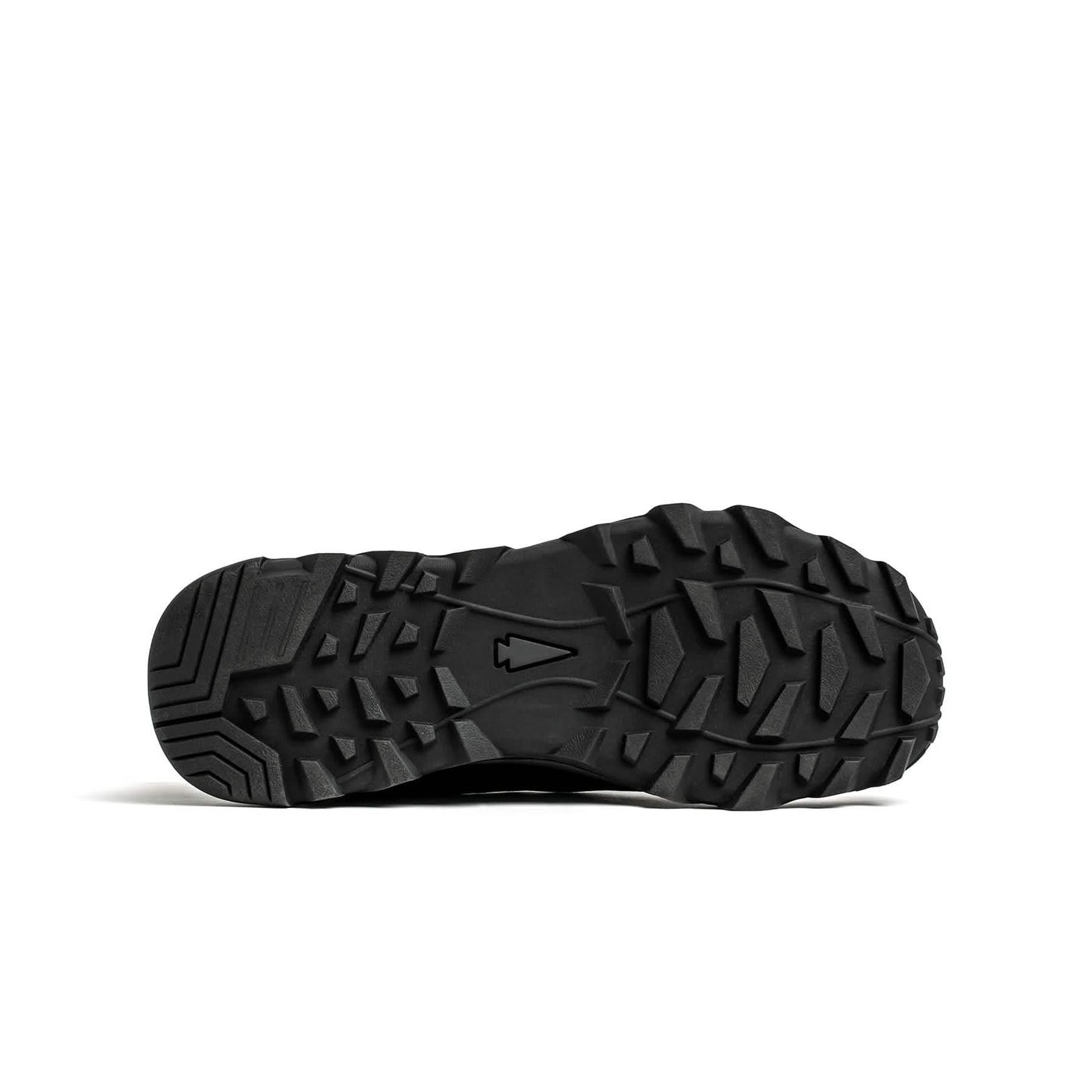 The image features the sole of a GORUCK Mackall - Black + Forged Iron trail shoe facing upward, displaying a rugged, textured design with deep grooves and patterns for optimal traction during Special Forces training.