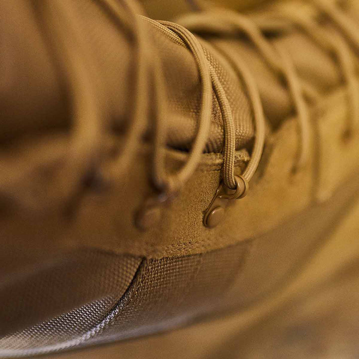 Close-up of the GORUCK MACV-1 High Top in Coyote Suede, showcasing its suede leather upper with detailed focus on the laces and stitching, highlighting the texture and craftsmanship. The all-terrain outsole ensures durability and grip.