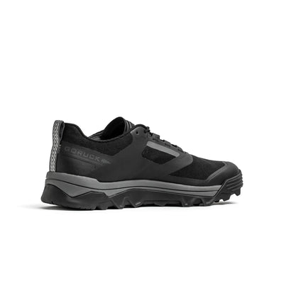 Introducing the Mackall - Black + Forged Iron from GORUCK, a sleek and durable athletic trail shoe designed for peak performance in Special Forces training. Featuring a rugged, textured sole and a synthetic upper, this shoe is perfectly crafted for outdoor activities. The brand's logo is prominently displayed on the side, ensuring both quality and reliability in any terrain.
