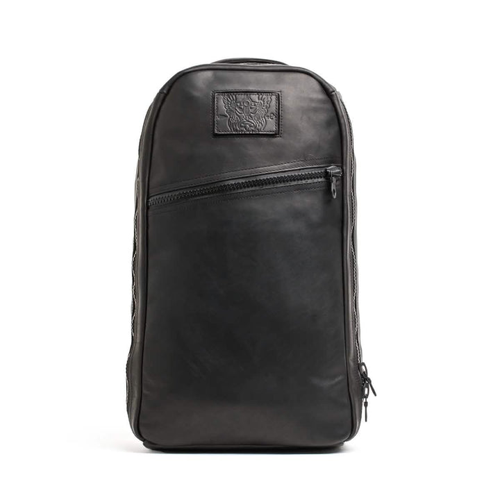 Introducing the Bullet Ruck x Carryology - Berserker Viking by GORUCK: a sleek black leather backpack with a rectangular shape that draws inspiration from the Viking Bullet Ruck. It boasts a front zipper pocket and a subtle embossed design on a small patch near the top, all while maintaining a modern, minimalist look.