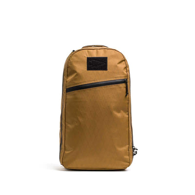 Bullet X-PAC daypack in tan, featuring a black AquaGuard zipper running diagonally across the front, displayed upright on a white background.