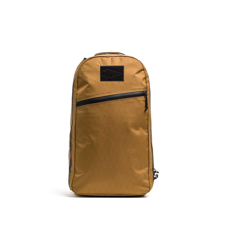 Bullet X-PAC daypack in tan, featuring a black AquaGuard zipper running diagonally across the front, displayed upright on a white background.
