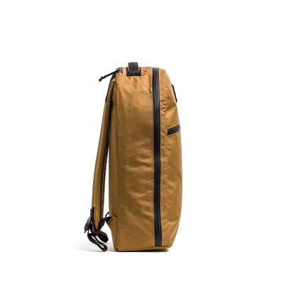Side view of the Bullet X-PAC daypack in tan with black AquaGuard zippers and straps, made from durable X-PAC material, shown against a white background.