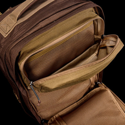 The GR2 - Ballistic Nylon Cordura, shown from above in brown, features multiple unzipped compartments and mesh pockets—making it a perfect carry-on compliant travel ruck.