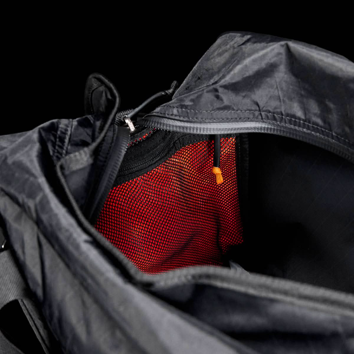 Open Kit Bag - X-PAC, featuring a visible red mesh pocket and an orange zipper pull, shown on a black background.