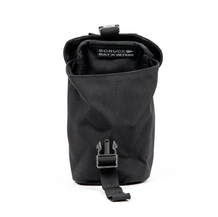 A black, cylindrical GORUCK Full Panel Water Bottle Pocket with a buckle strap. Inside, there's a label stating it's Built in Vietnam. It includes a MOLLE attachment system for customizable carry options and is open to display its spacious interior, ideal for organizing essentials.