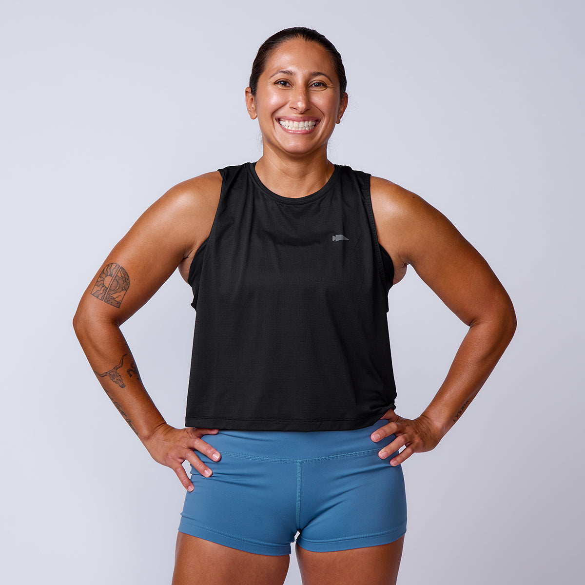 Smiling woman wearing Women’s Squat Shorts - ToughFlex, hands on hips, poses against a plain background.