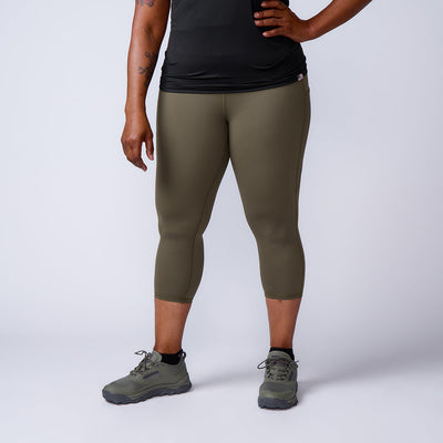 Person wearing olive green Women’s Training Leggings Pocket - ToughFlex, black shirt, and green sneakers stands against a plain light background.