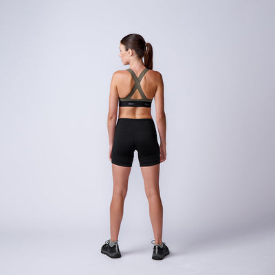 Woman wears ToughFlex Women’s Biker Shorts and sneakers, standing with her back to the camera against a plain light gray background.
