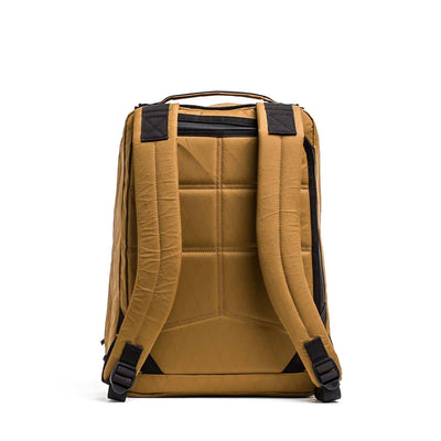 The GR0 - X-PAC is a mustard yellow lightweight rucksack made from waterproof X-PAC material, featuring padded shoulder straps and black accent details, shown from the back.