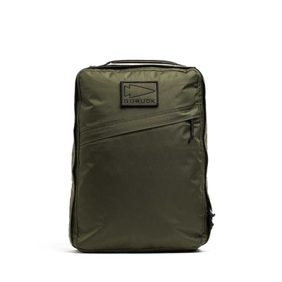 The GR0 - X-PAC is an olive green backpack made from lightweight, waterproof rucksack material, featuring a diagonal zip pocket and a rectangular "GORUCK" patch on the front.