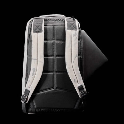 A black and white GR1 USA - Cordura backpack by GORUCK is displayed from the back against a black background. Its padded straps ensure comfort, while the slightly open main compartment reveals a glimpse of its dark interior pocket. Featuring a modern, minimalist design, this backpack is ideal for special forces training.