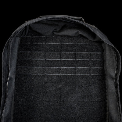 Open black GR1 Shooter 26L - Built by SCARS backpack with an empty, flat interior and tough CORDURA® fabric. Features MOLLE webbing on the back panel—trusted by the SCARS team—displayed against a black background.
