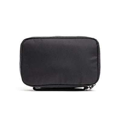 The GR1 Field Pocket - X-PAC is a rectangular black travel pouch with AquaGuard zippers, shown standing upright on a white background—ideal for organizing electronics.