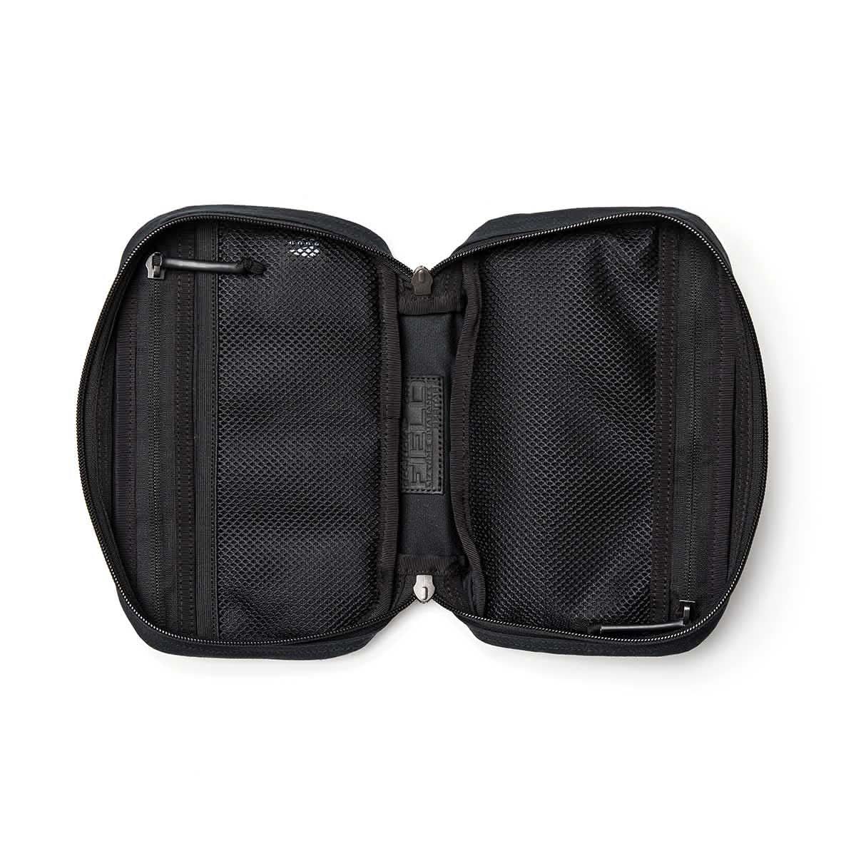 The GR1 Field Pocket - Waxed Canvas travel pouch is shown unzipped, revealing two mesh compartments and small interior pockets.