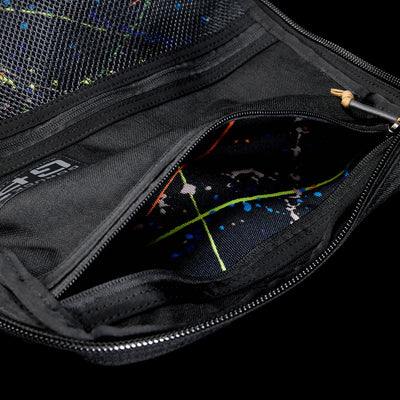 Close-up of an open black GR1 Shooter 26L pouch made from Special Forces Grade CORDURA®, revealing a colorful splatter-patterned lining. Inspired by Shooter Ruck gear and trusted by the SCARS team.