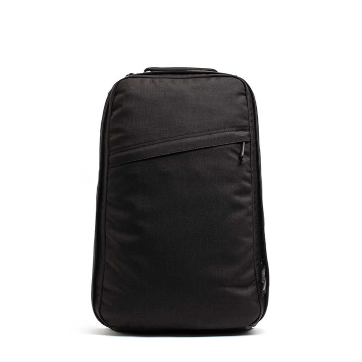 The GR1 USA Slick backpack in Ballistic Nylon Cordura, shown upright on a white background, features a sleek black design with Special Forces-grade quality and a front diagonal zipper pocket.