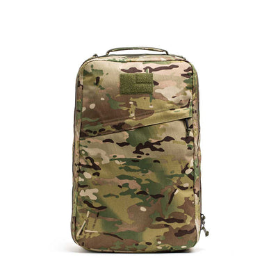 The GR1 USA - X-PAC camouflage backpack is rectangular, made from durable X-PAC material, and features a zippered front pocket on a white background.