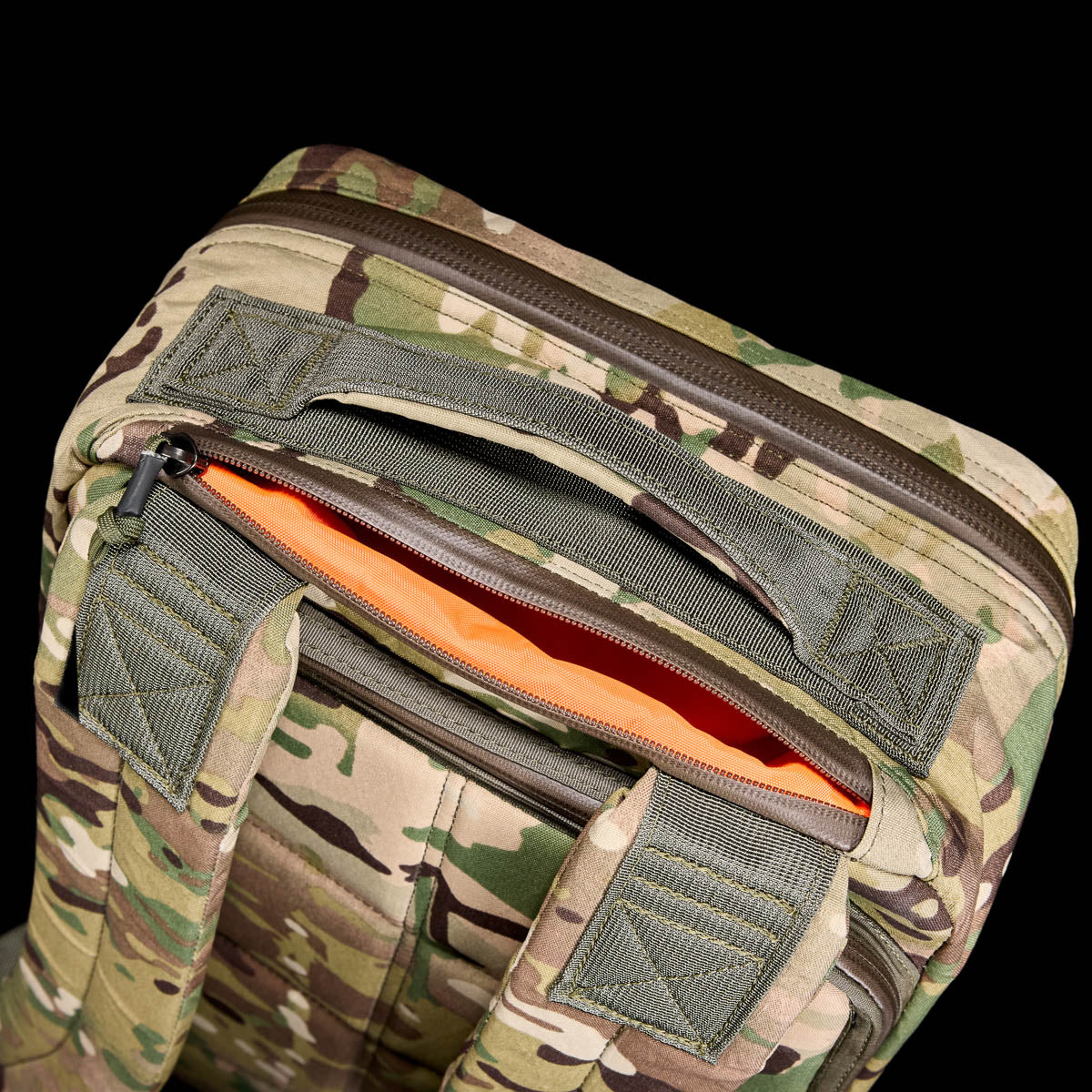 Close-up of the GR1 USA - X-PAC lightweight camouflage backpack featuring an open top with an orange interior against a black background.