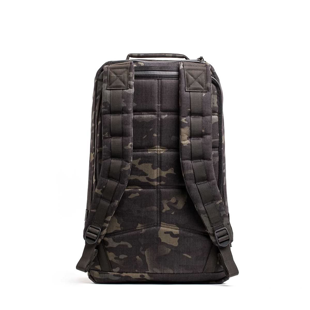 The GR1 USA - Cordura (The Original Ruck) is a black camouflage backpack viewed from the back, featuring Special Forces-grade materials, padded shoulder straps, and a top handle.