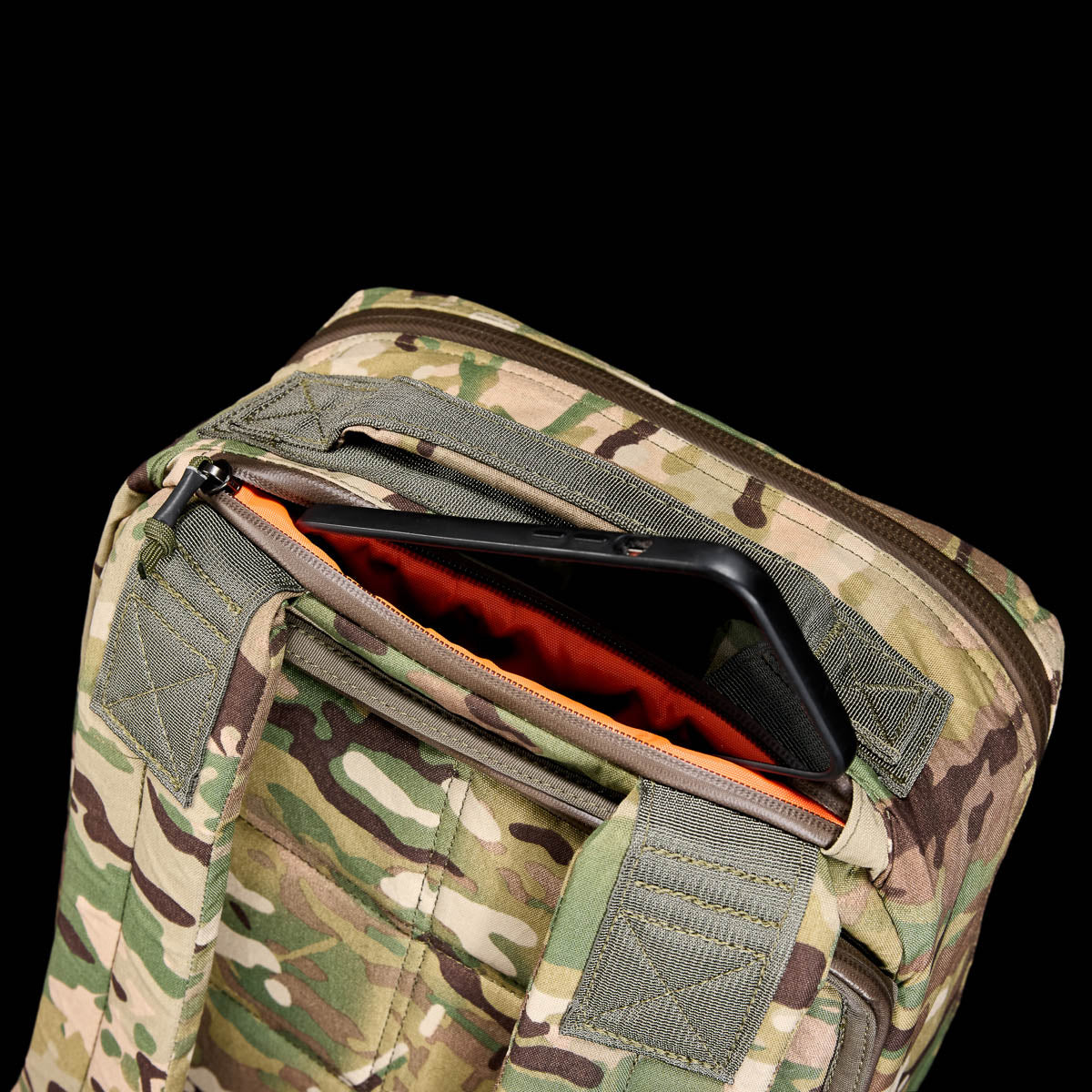 The GR1 USA - X-PAC rucksack is waterproof and features an open top zipper, revealing a bright orange X-PAC interior with a convenient phone compartment.