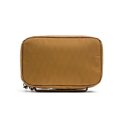 The GR1 Field Pocket - X-PAC is a rectangular tan pouch with a diamond pattern, made from waterproof X-PAC fabric and featuring a top zipper.