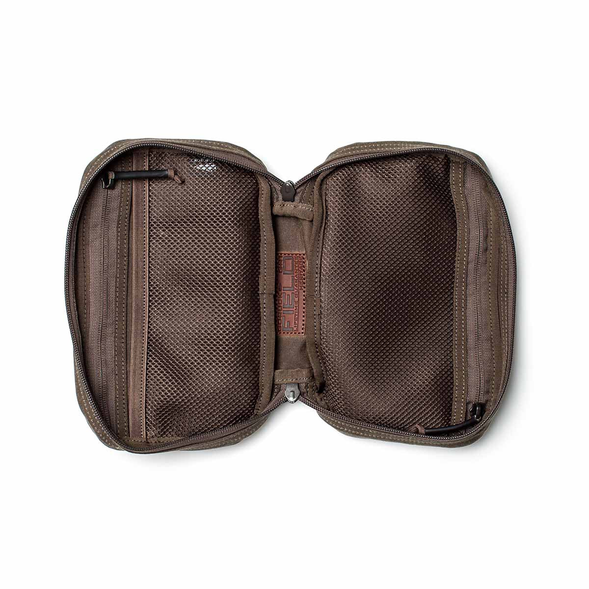 The GR1 Field Pocket - Waxed Canvas is shown unzipped on a white background, revealing mesh pockets and compartments. Made from durable waxed canvas, this pouch offers both style and practical organization.