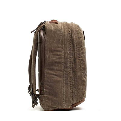 GR2 - Heritage Waxed Canvas Backpack in brown waxed duck canvas stands upright, shown from the side with visible zippers and sturdy straps.