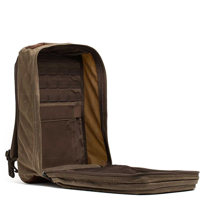 The GR2 - Heritage Waxed Canvas is a brown backpack with a main compartment that fully unzips to reveal internal pockets and organizers.