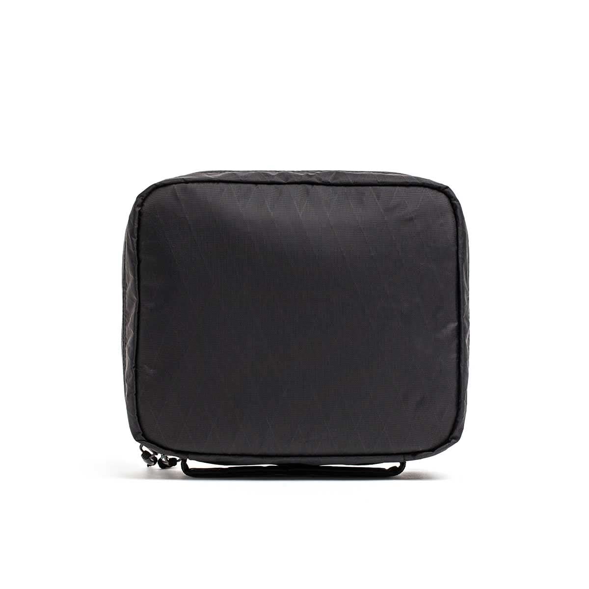 The GR2 Field Pocket - X-PAC is a black, square travel pouch with a small strap, made from waterproof fabric and AquaGuard zippers, displayed on a white background.