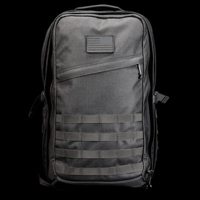 The GR2 USA Throwback is a black tactical travel backpack, crafted from rugged 1000D Cordura with MOLLE webbing and a small front patch, shown against a black background.