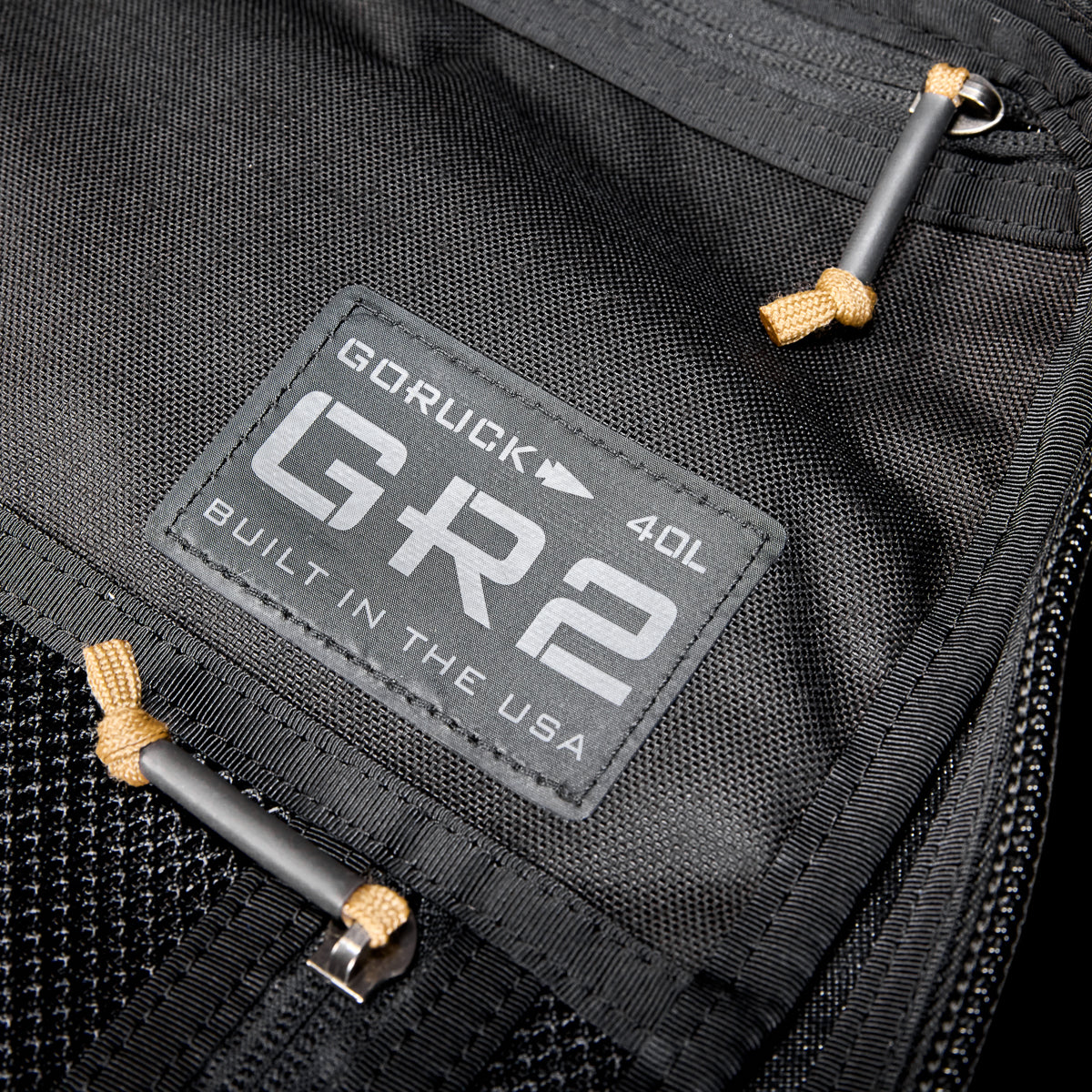 Close-up of a black GR2 USA Throwback travel backpack, crafted from rugged 1000D Cordura, featuring a "Built in the USA" patch.