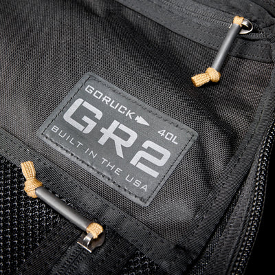 Close-up of a black GR2 USA Throwback travel backpack, crafted from rugged 1000D Cordura, featuring a "Built in the USA" patch.