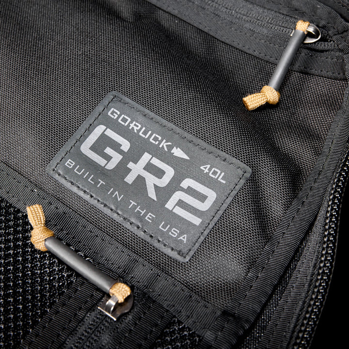Close-up of a black GR2 USA Throwback travel backpack, crafted from rugged 1000D Cordura, featuring a "Built in the USA" patch.
