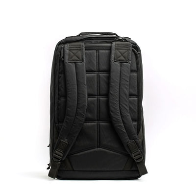 The GR2 X-PAC backpack is shown from the back, featuring padded shoulder straps, a quilted back panel, and waterproof AquaGuard zippers.