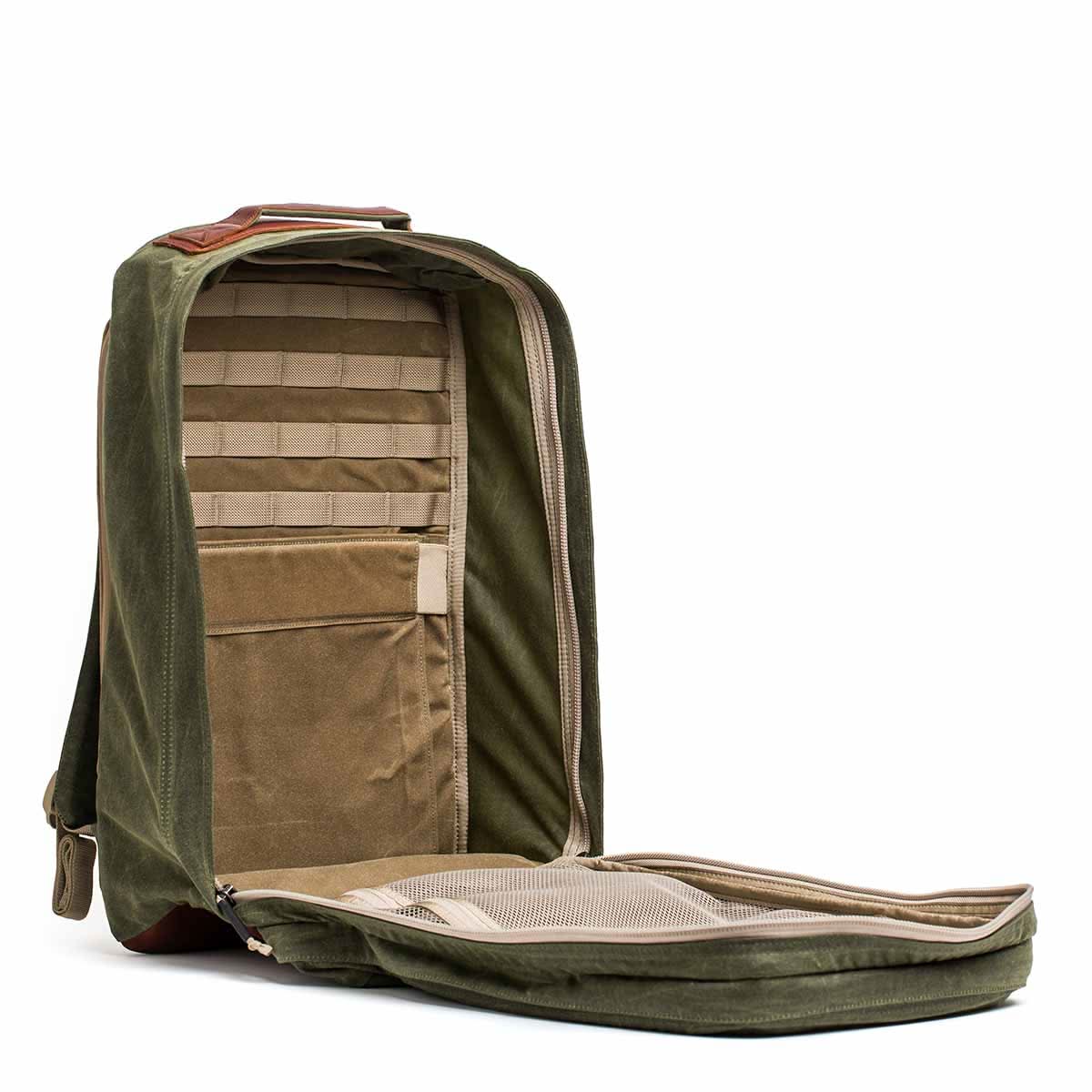 The GR2 - Waxed Canvas in olive green features a front flap open to reveal multiple interior pockets and compartments, all crafted from durable waxed duck canvas.