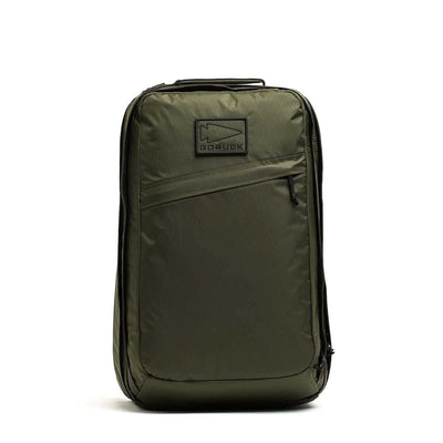 Olive green GR2 X-PAC backpack standing upright, featuring a front zipper pocket with AquaGuard zippers and a top handle.