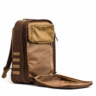 The GR2 - Ballistic Nylon Cordura ruck in brown and tan features a front pocket and spacious mesh-lined compartment, shown partially unzipped—ideal for use as a carry-on compliant travel bag.