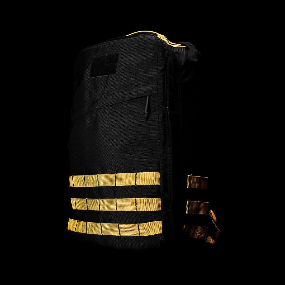 The GR1 USA - Cordura by GORUCK showcases a sophisticated design reminiscent of the GORUCK Challenge, featuring yellow straps on a black backpack. This GR1-style bag embodies the durability synonymous with Special Forces equipment.