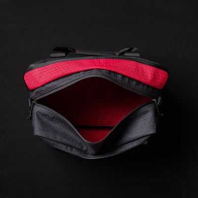 The Kit Bag x Carryology - GRXC2 Samurai 2.0 is shown open from above, revealing its red patterned interior and custom technical fabric, set against a dark background.