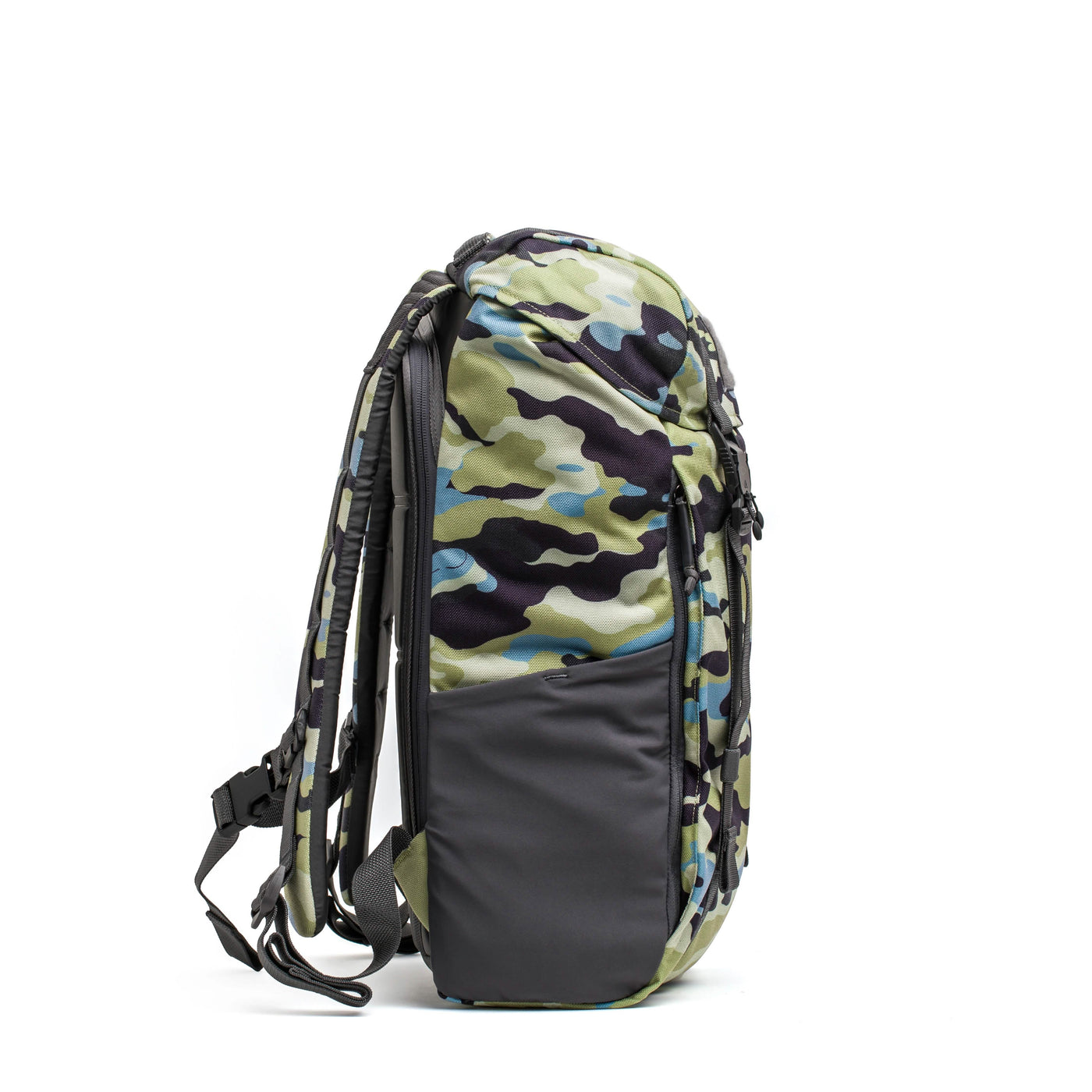Side view of the M24 - Cordura backpack by GORUCK, crafted from durable materials in a camouflage pattern. It features a black front pocket and adjustable straps and showcases modern shades of green, grey, and black.